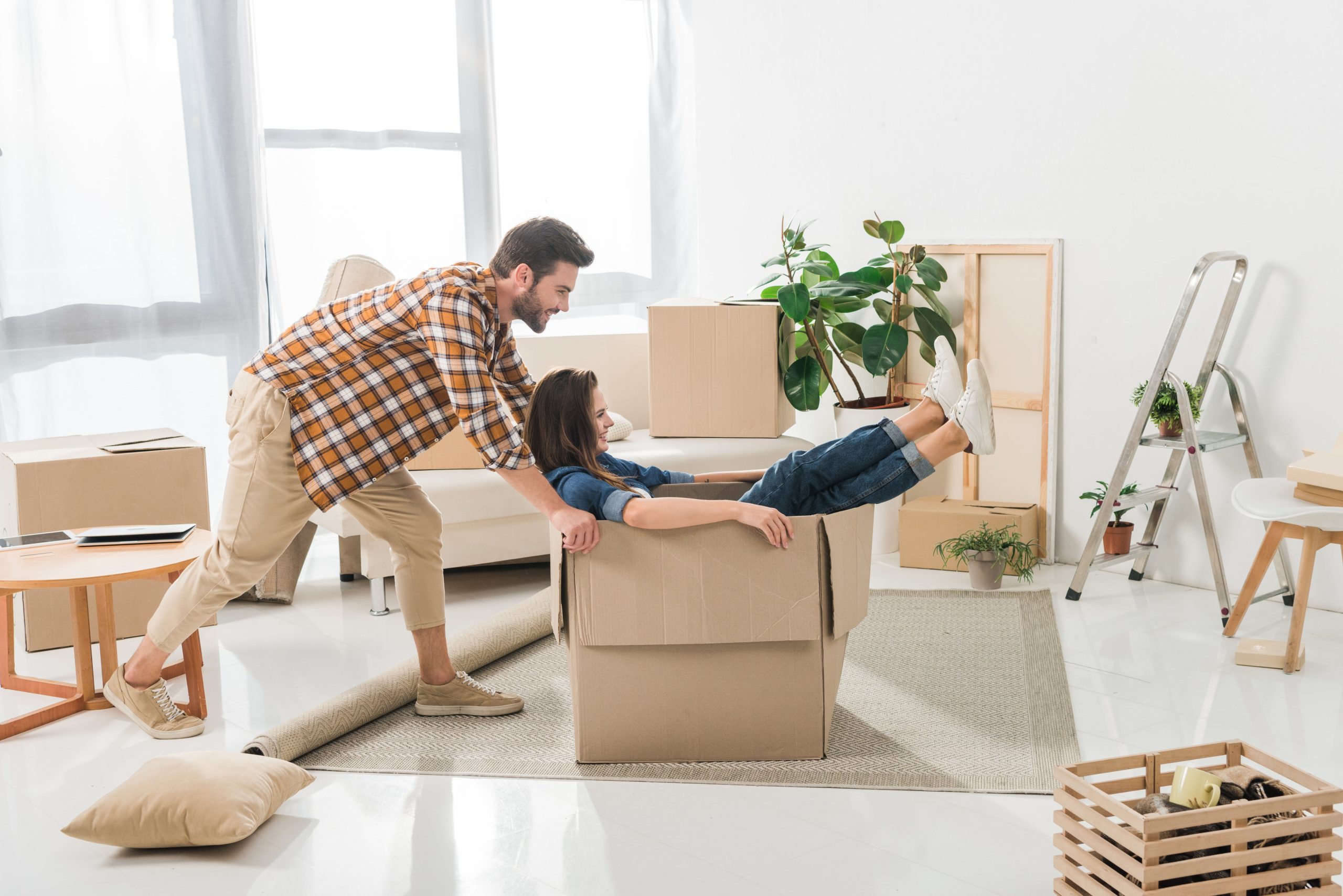 Man pushing woman in box at new home