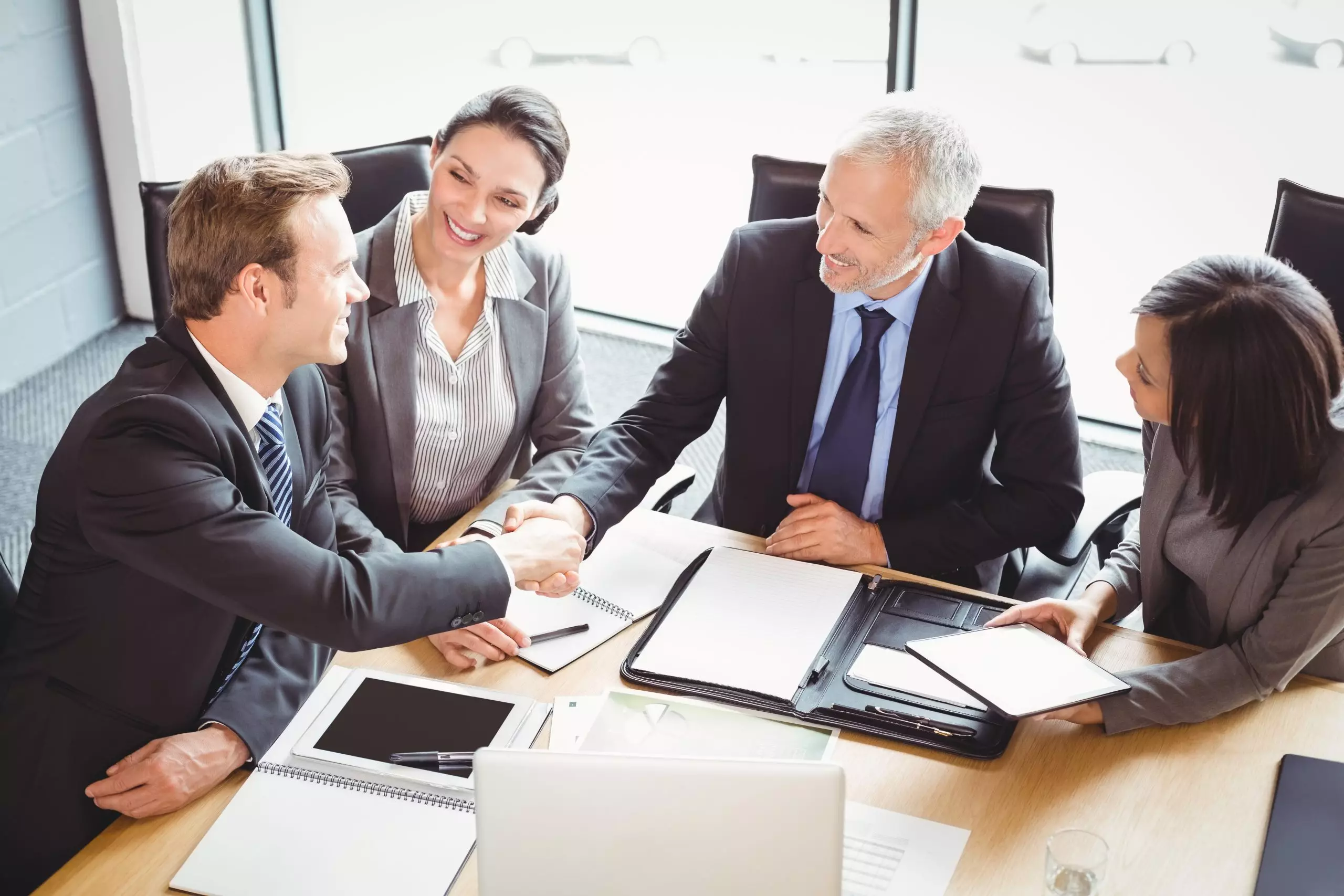 Businessmen shaking hands in conference room in office